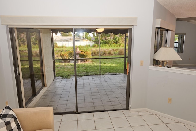 doorway to outside with light tile patterned floors, a textured ceiling, and vaulted ceiling