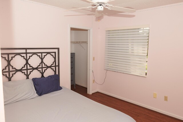 bedroom featuring a textured ceiling, a closet, ceiling fan, and dark wood-type flooring