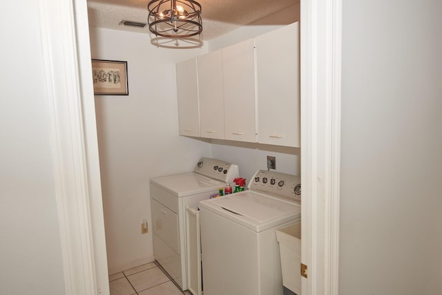 laundry area featuring cabinets, a textured ceiling, sink, light tile patterned floors, and independent washer and dryer