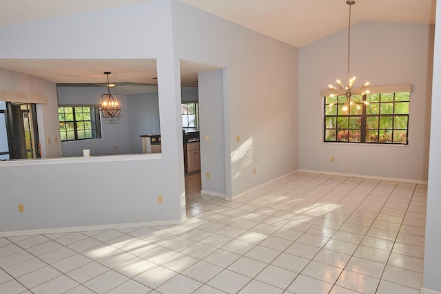 tiled spare room featuring a notable chandelier and vaulted ceiling