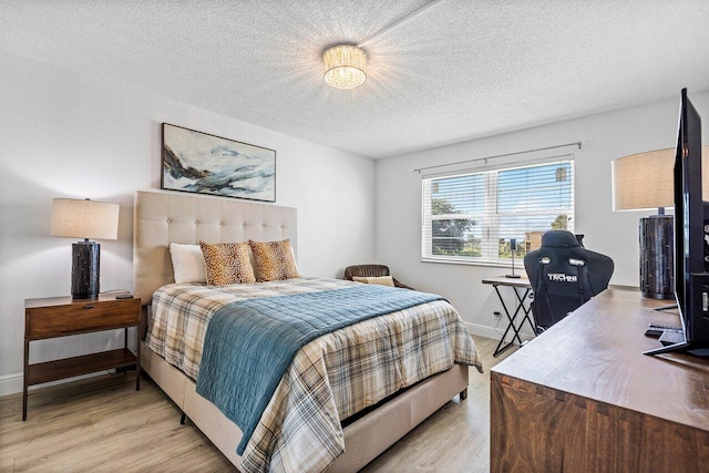 bedroom with light hardwood / wood-style floors and a textured ceiling