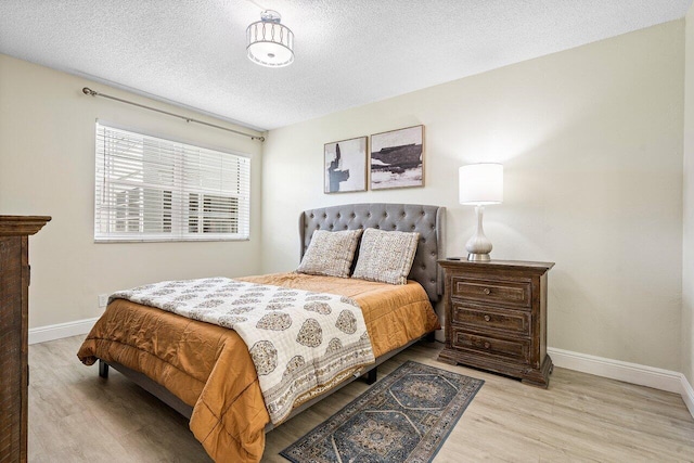 bedroom featuring a textured ceiling and light hardwood / wood-style floors