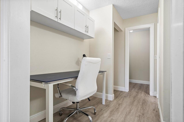 office featuring light hardwood / wood-style floors and a textured ceiling