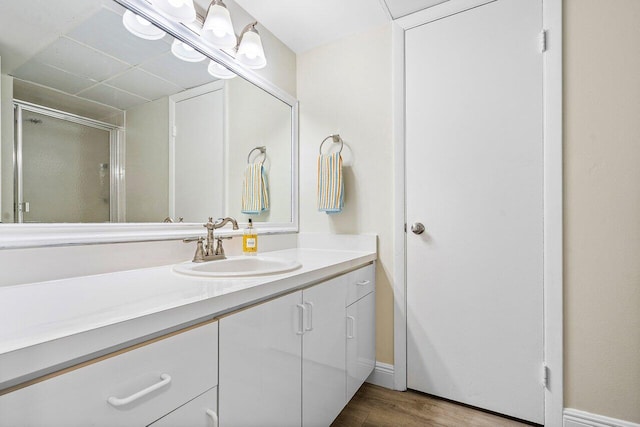 bathroom featuring hardwood / wood-style floors, vanity, and a shower with shower door