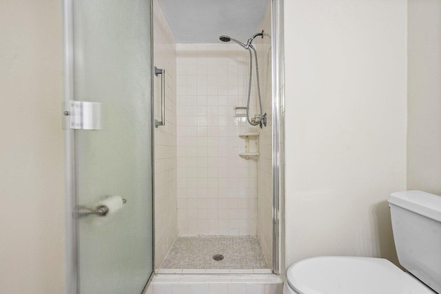 bathroom with toilet and an enclosed shower