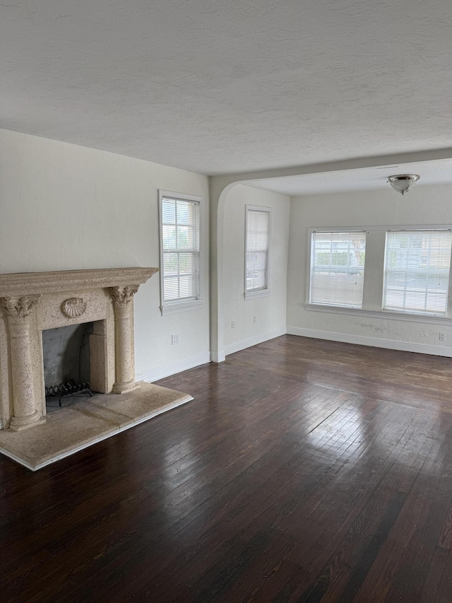 unfurnished living room with hardwood / wood-style flooring, a wealth of natural light, and a premium fireplace