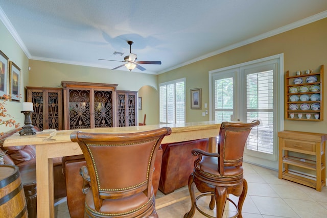 bar featuring ceiling fan, light tile patterned floors, and crown molding