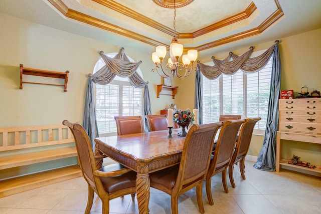 dining area with a chandelier, light tile patterned floors, crown molding, and a tray ceiling