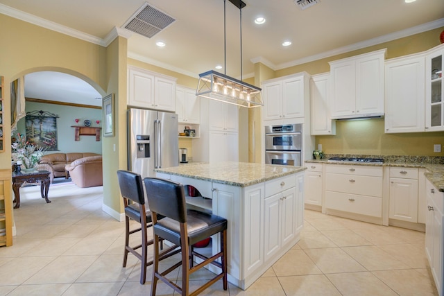 kitchen with white cabinetry, crown molding, decorative light fixtures, a kitchen island, and appliances with stainless steel finishes