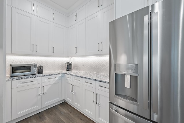 kitchen with decorative backsplash, white cabinetry, and stainless steel fridge with ice dispenser