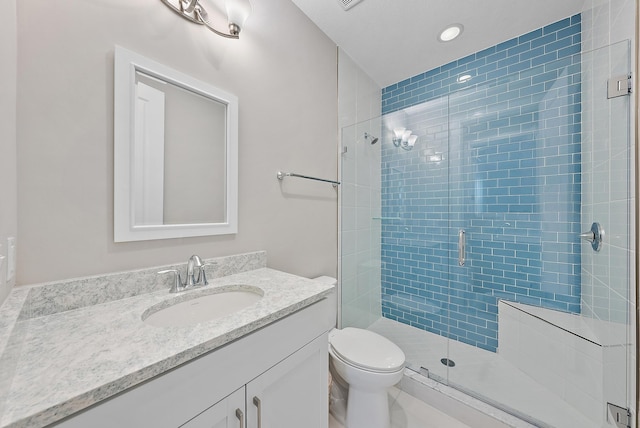 bathroom with vanity, toilet, and a shower with door