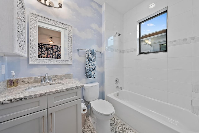 full bathroom with vanity, tile patterned flooring, tiled shower / bath, and toilet