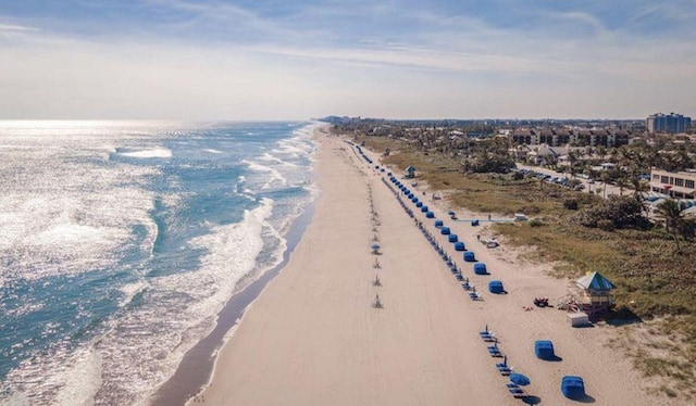 drone / aerial view featuring a water view and a beach view