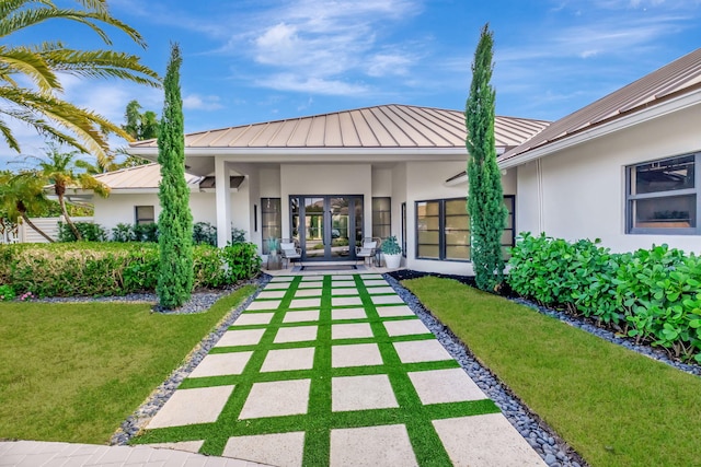 rear view of property featuring a lawn