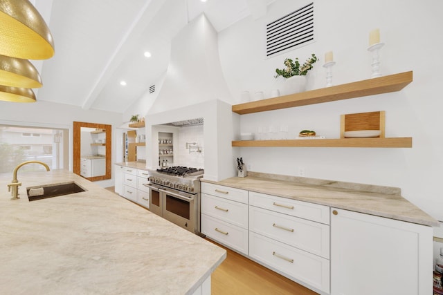 kitchen featuring sink, white cabinetry, double oven range, vaulted ceiling with beams, and light stone countertops