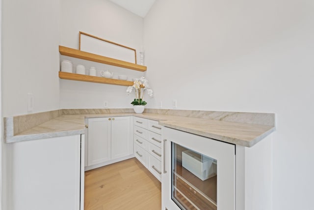 kitchen featuring wine cooler, light hardwood / wood-style floors, and white cabinets