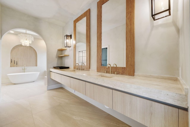 bathroom featuring a washtub, vanity, and a chandelier