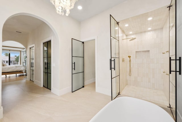 bathroom with a chandelier and separate shower and tub