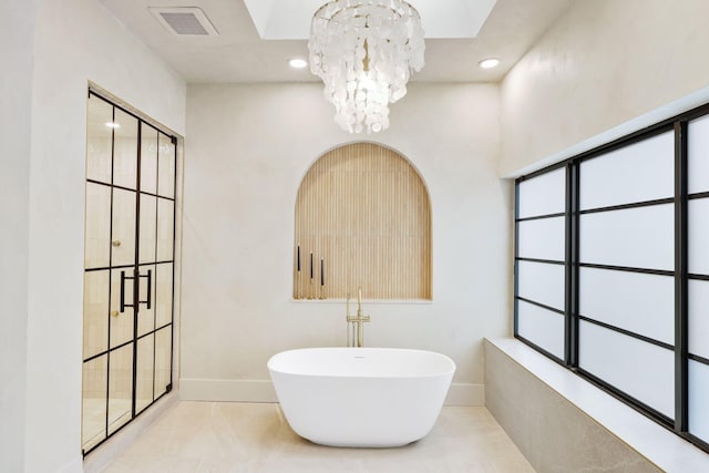 bathroom with a bath, tile patterned floors, and a chandelier