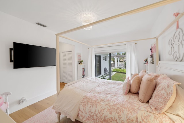 bedroom featuring access to exterior, light hardwood / wood-style floors, and a closet