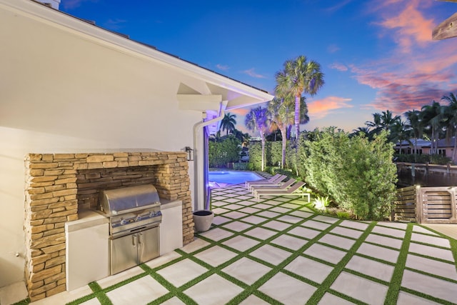 patio terrace at dusk with grilling area and exterior kitchen