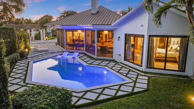 pool at dusk featuring a patio