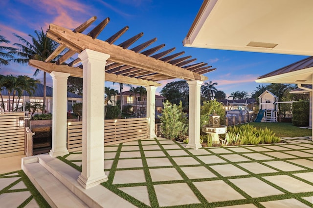 patio terrace at dusk with a pergola and a playground