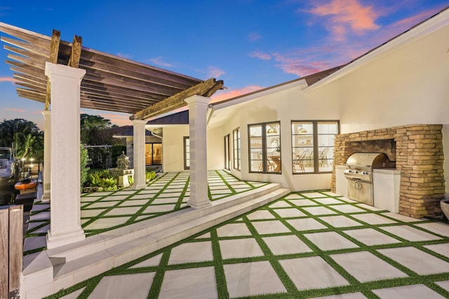 patio terrace at dusk featuring area for grilling, a pergola, and grilling area