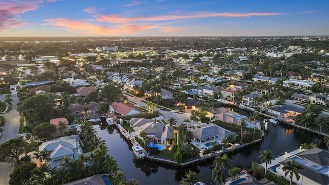 aerial view at dusk featuring a water view