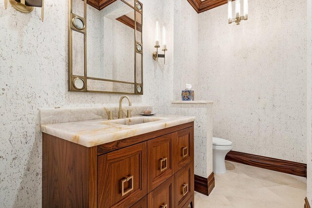 kitchen with wall chimney exhaust hood, a high ceiling, light stone counters, an island with sink, and ornamental molding