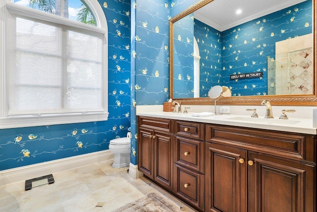 bathroom featuring double vanity, a sink, toilet, and baseboards