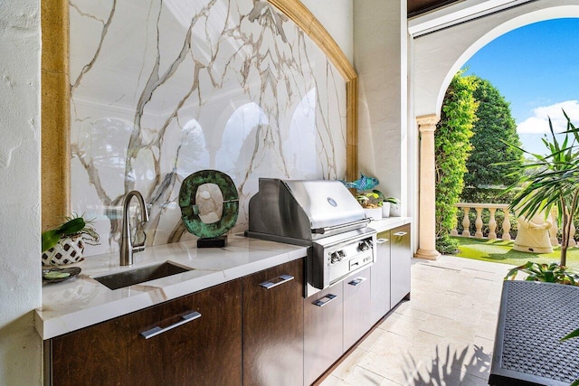 view of patio / terrace with exterior kitchen, a grill, and a sink