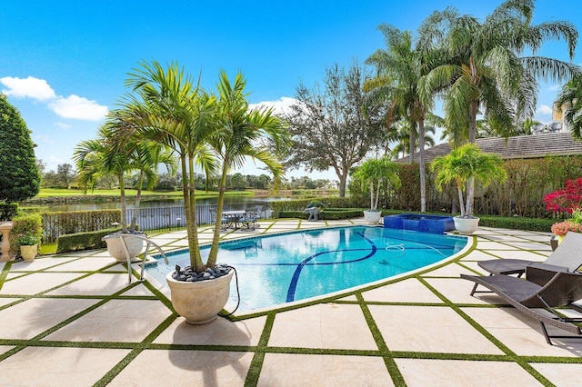 view of pool featuring a jacuzzi, a water view, and a patio area