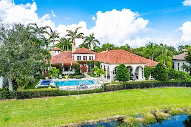 back of house with a lawn and a fenced in pool