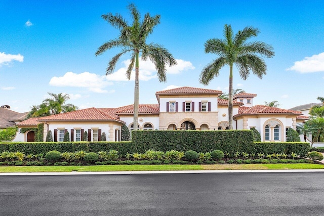 mediterranean / spanish house with stucco siding and a tiled roof