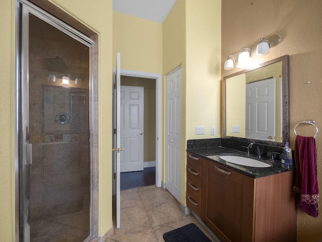 bathroom featuring tile patterned floors, vanity, and a shower with shower door