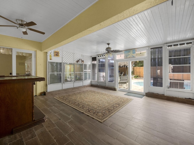 unfurnished sunroom featuring ceiling fan and french doors