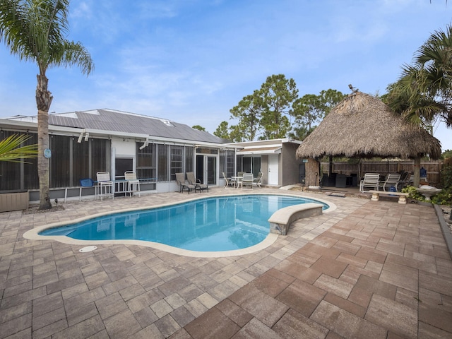 view of pool featuring a gazebo, a sunroom, and a patio