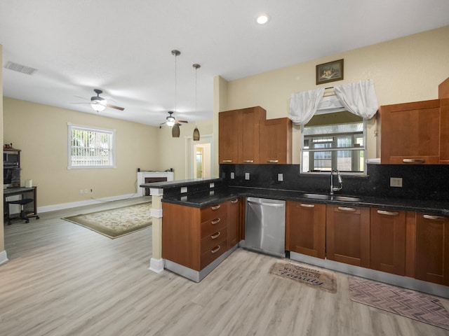 kitchen with kitchen peninsula, sink, light hardwood / wood-style flooring, dishwasher, and hanging light fixtures