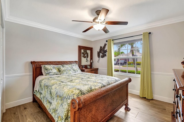 bedroom featuring ceiling fan, crown molding, and hardwood / wood-style flooring