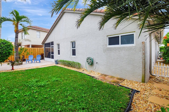 back of house with a lawn and a patio