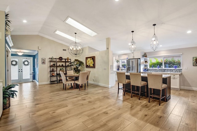 kitchen with pendant lighting, a center island, light wood-type flooring, and stainless steel refrigerator with ice dispenser