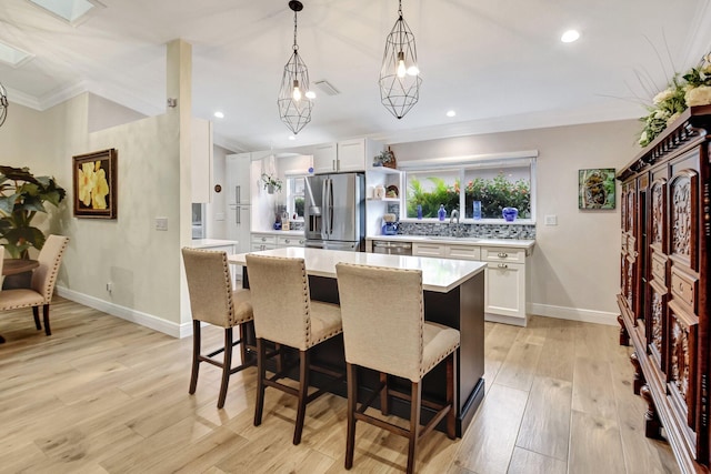 kitchen with white cabinets, stainless steel fridge with ice dispenser, and light hardwood / wood-style flooring