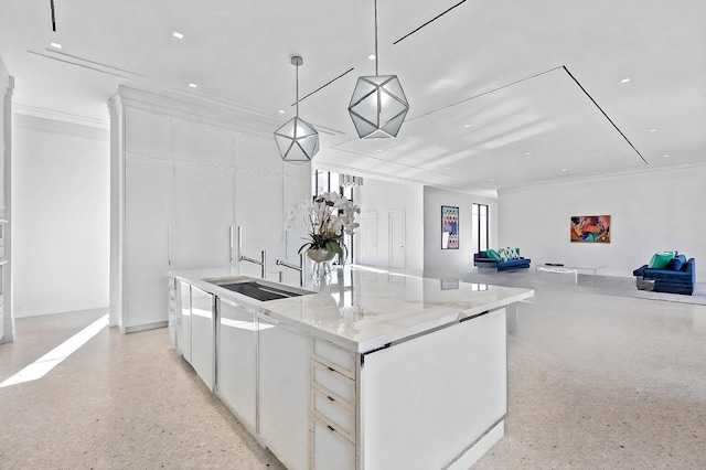 kitchen with white cabinetry, a large island, light stone counters, and decorative light fixtures