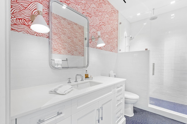 bathroom featuring vanity, tile patterned flooring, toilet, tile walls, and walk in shower