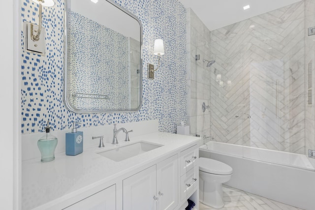 full bathroom featuring vanity, tiled shower / bath combo, and toilet