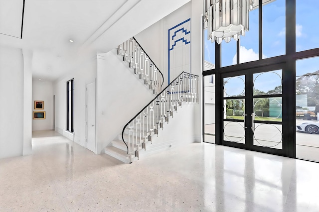 entryway with a towering ceiling and french doors