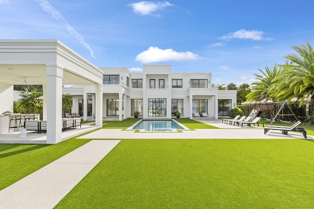 rear view of house with a yard and a patio