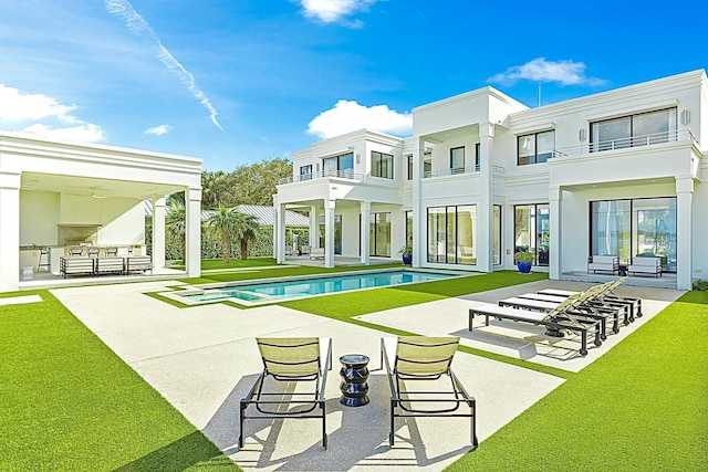 rear view of house with area for grilling, a patio area, a balcony, and a yard