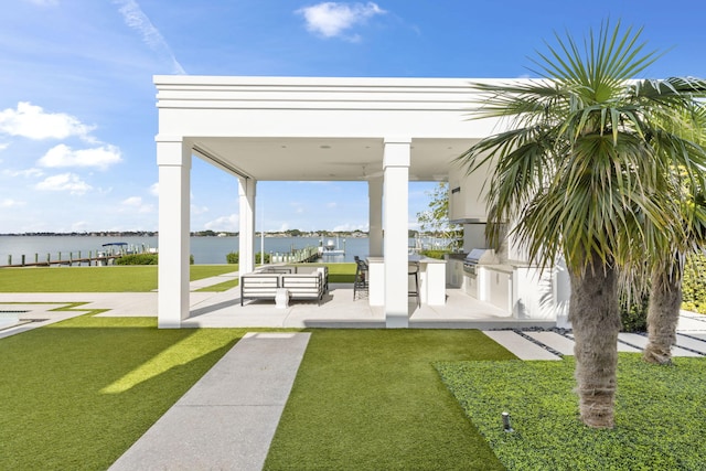 view of yard with area for grilling, a water view, and a patio